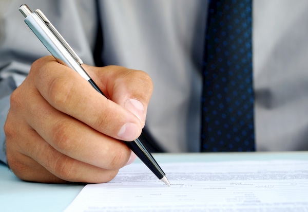 A CRMO signing a risk management plan proposal for his business